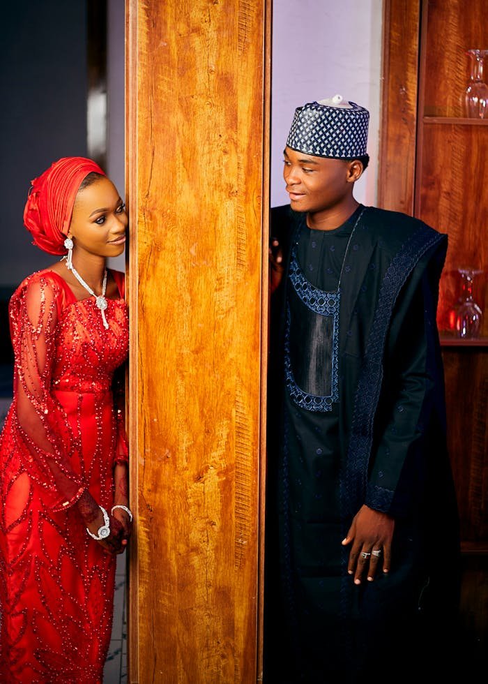 collection-04 Couple in vibrant African attire sharing a joyful moment indoors.